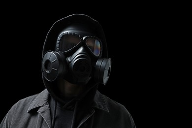 Photo of Man in gas mask on black background, low angle view. Space for text