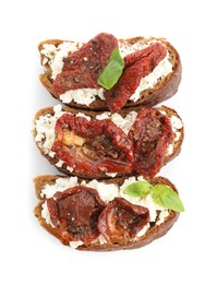 Photo of Delicious ricotta bruschettas with sun dried tomatoes and basil isolated on white, top view