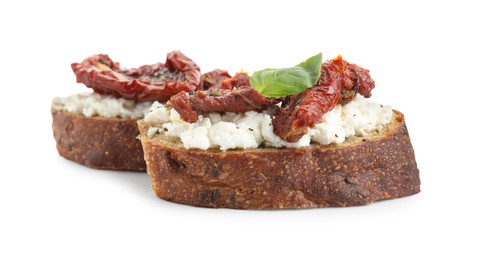 Photo of Delicious ricotta bruschettas with sun dried tomatoes and basil isolated on white