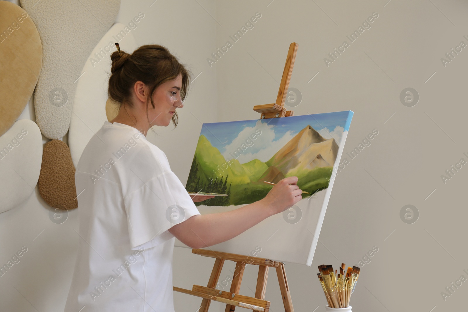 Photo of Woman drawing landscape with brush in studio