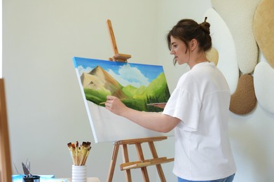 Photo of Woman drawing landscape with brush in studio