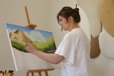 Photo of Woman drawing landscape with brush in studio