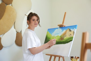 Photo of Woman drawing landscape with brush in studio