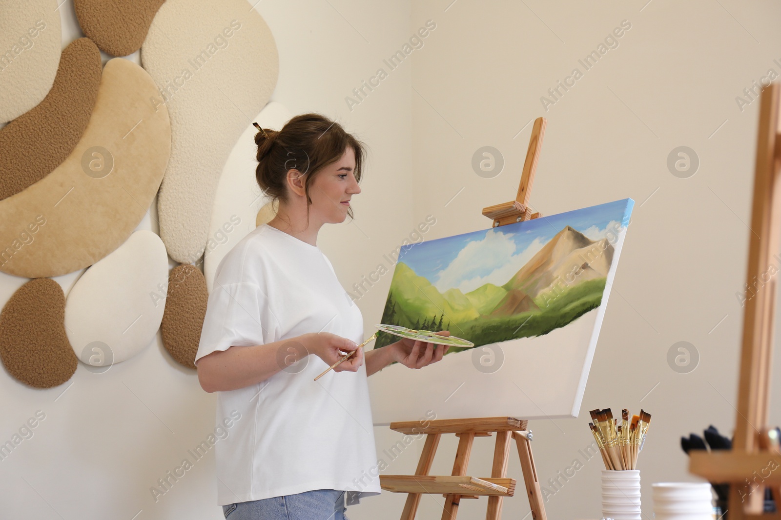 Photo of Woman drawing landscape with brush in studio