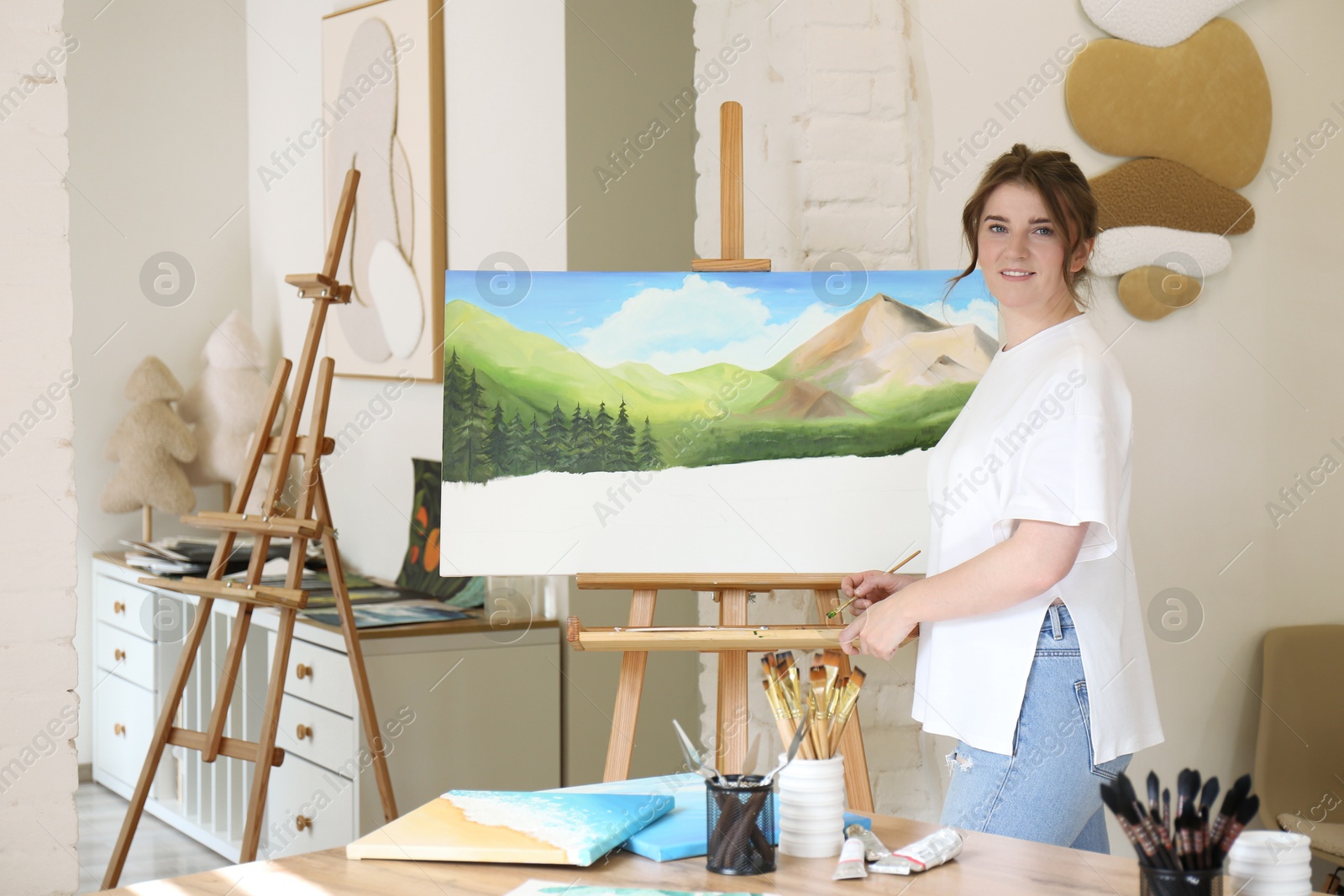 Photo of Woman drawing landscape with brush in studio