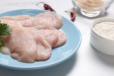 Photo of Cooking schnitzel. Raw meat, flour and chili peppers on white table, closeup