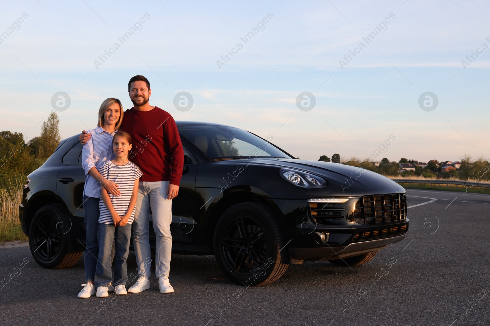 Photo of Happy parents and their daughter near car outdoors