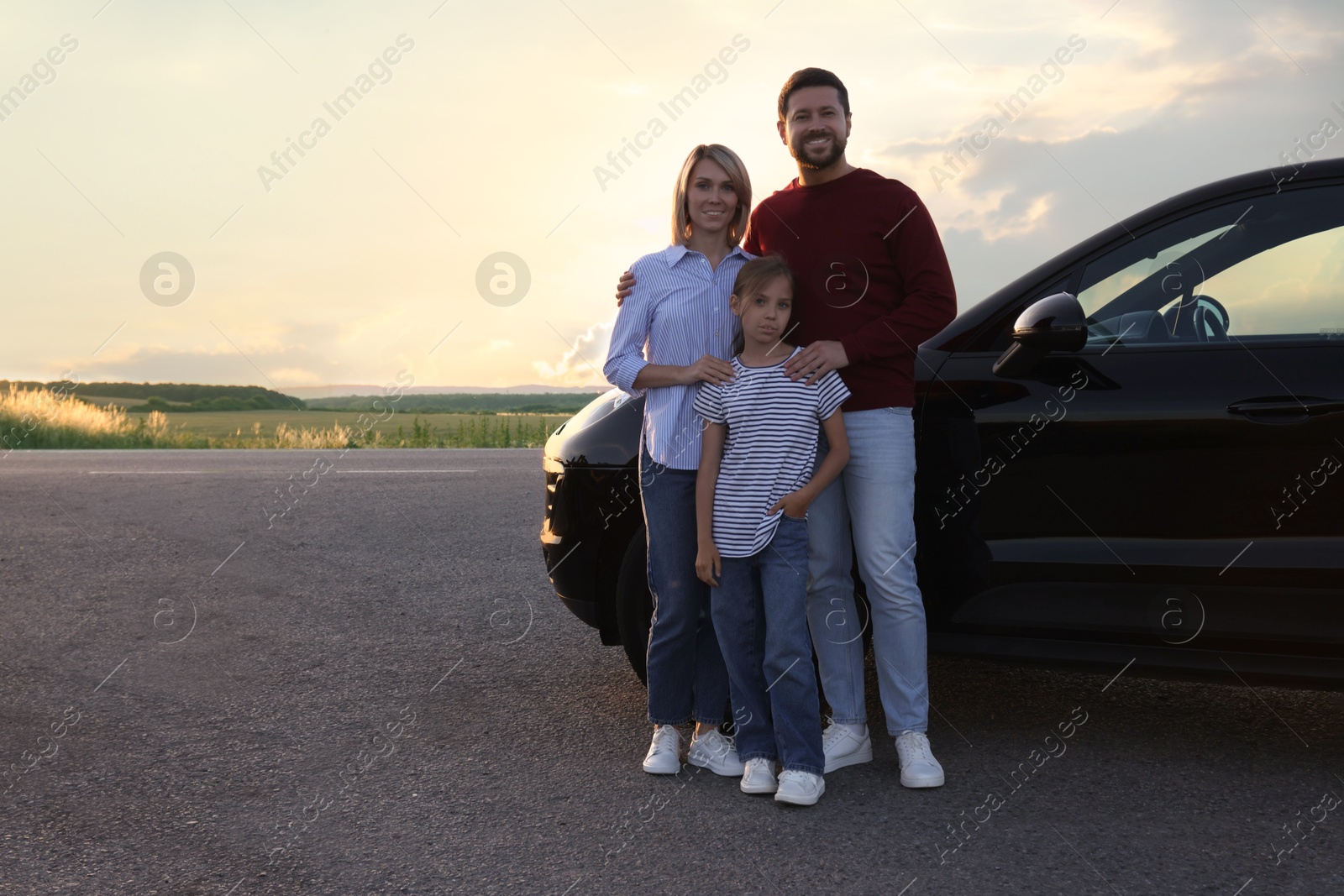 Photo of Happy parents and their daughter near car outdoors, space for text