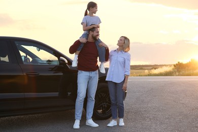Happy parents and their daughter near car outdoors, space for text