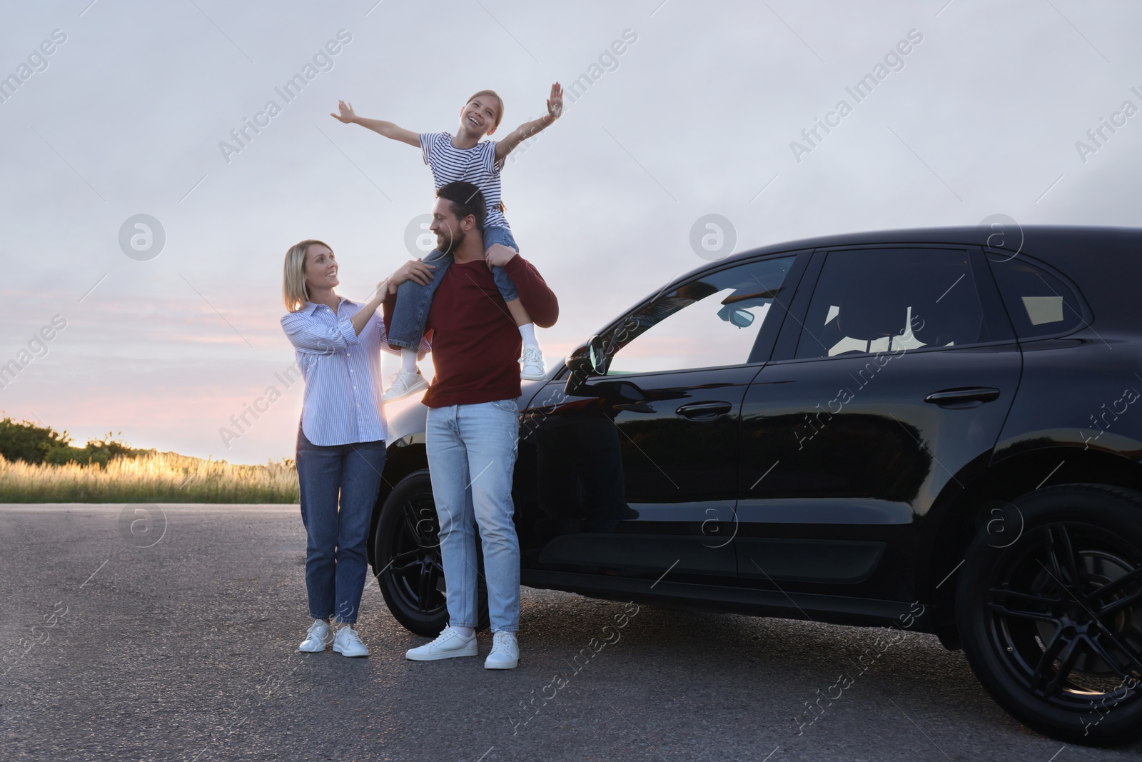 Photo of Happy parents and their daughter near car outdoors