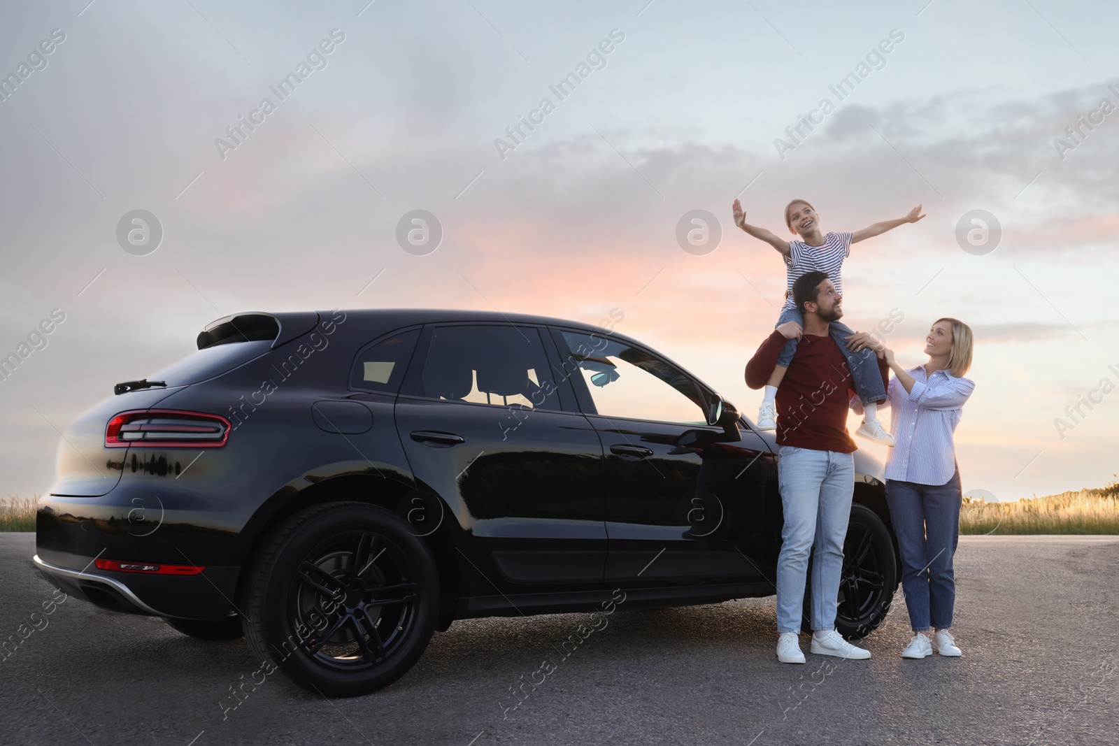 Photo of Happy parents and their daughter near car outdoors
