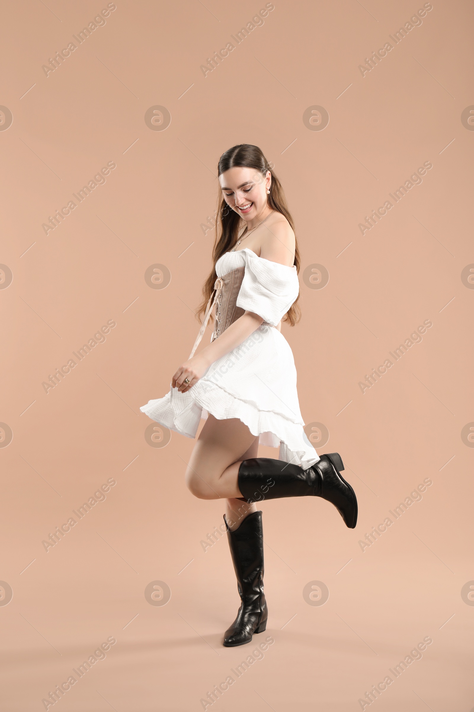 Photo of Smiling woman in velvet corset on beige background
