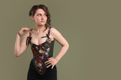 Photo of Beautiful woman in stylish corset on green background. Space for text