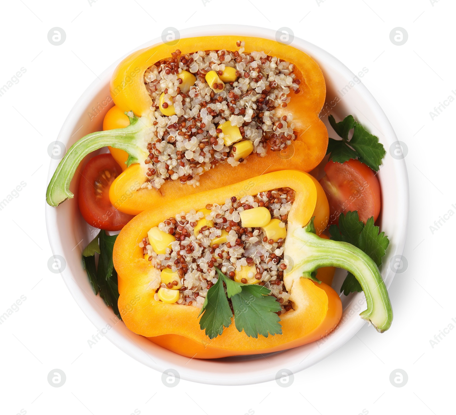 Photo of Quinoa stuffed bell pepper, tomatoes and parsley in bowl isolated on white, top view