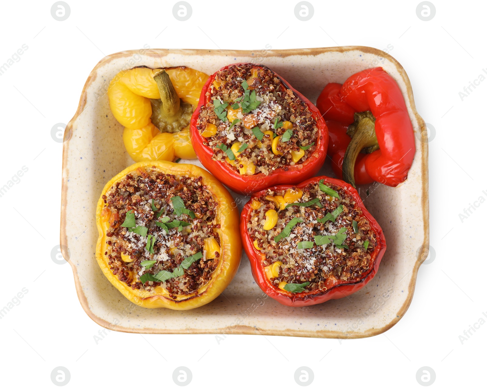 Photo of Tasty quinoa stuffed bell peppers with corn in baking dish isolated on white, top view