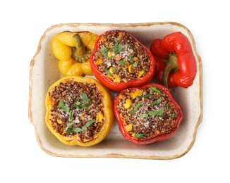 Photo of Tasty quinoa stuffed bell peppers with corn in baking dish isolated on white, top view