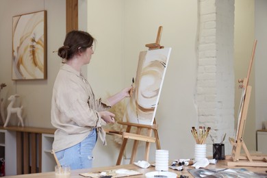 Woman with palette knife drawing picture in studio