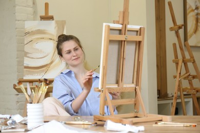 Photo of Woman with brush drawing picture at table in studio