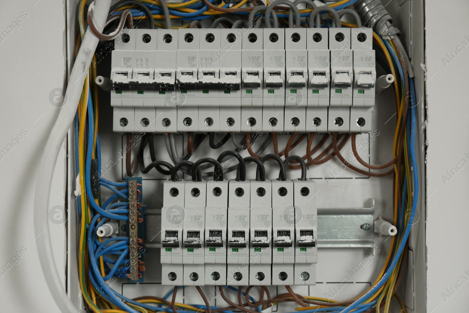Photo of Fuse box with many electric meters and wires on light wall, closeup