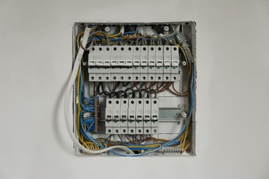 Photo of Fuse box with many electric meters and wires on light wall