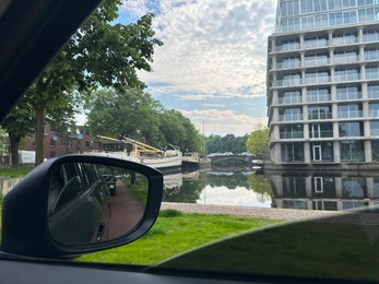 Canal with boats in city, view from driver's seat