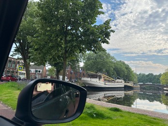 Photo of Canal with boats in city, view from driver's seat