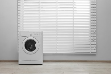 One washing machine near window in laundry room