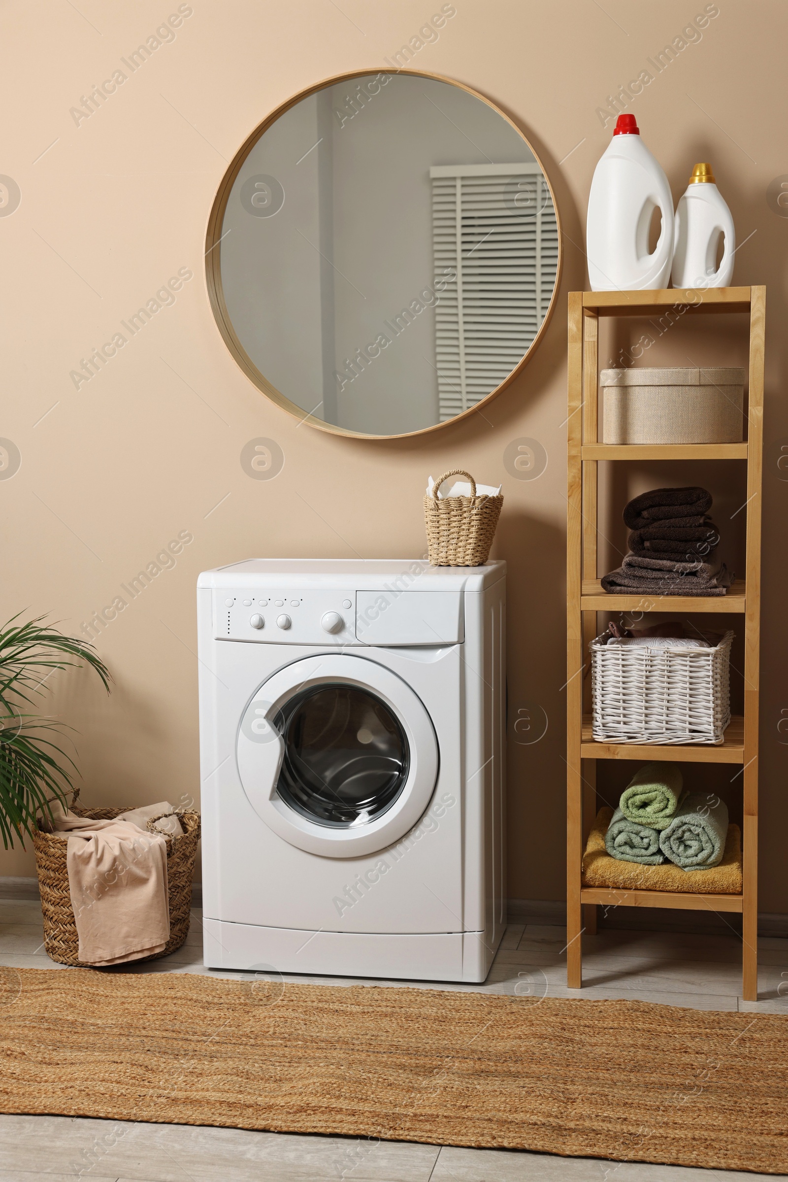 Photo of Stylish laundry room interior with washing machine, furniture and baskets