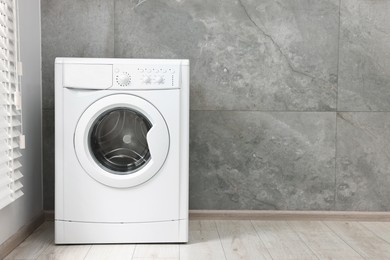 Photo of One washing machine in laundry room, space for text