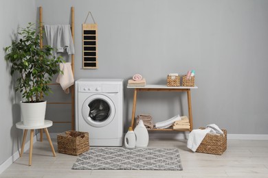 Washing machine, storage bench, detergents, laundry and houseplant indoors