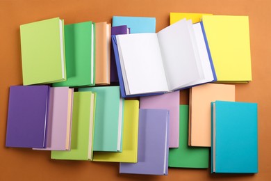 Photo of Many colorful books on orange background, flat lay