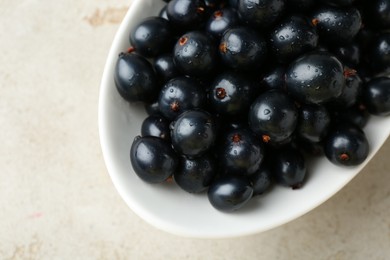 Photo of Ripe black currants in bowl on light table, top view