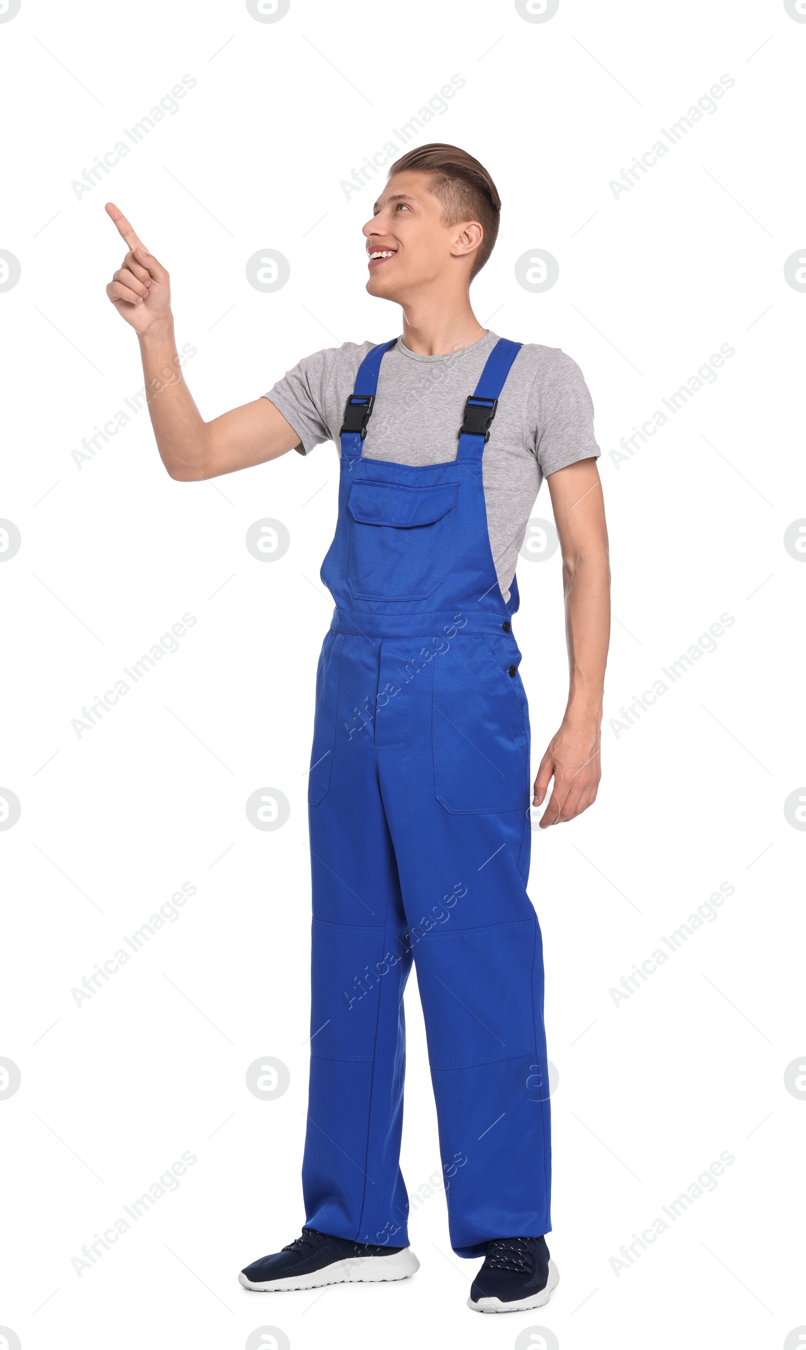 Photo of Smiling auto mechanic pointing at something on white background