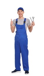 Photo of Smiling auto mechanic with wrenches showing thumb up on white background