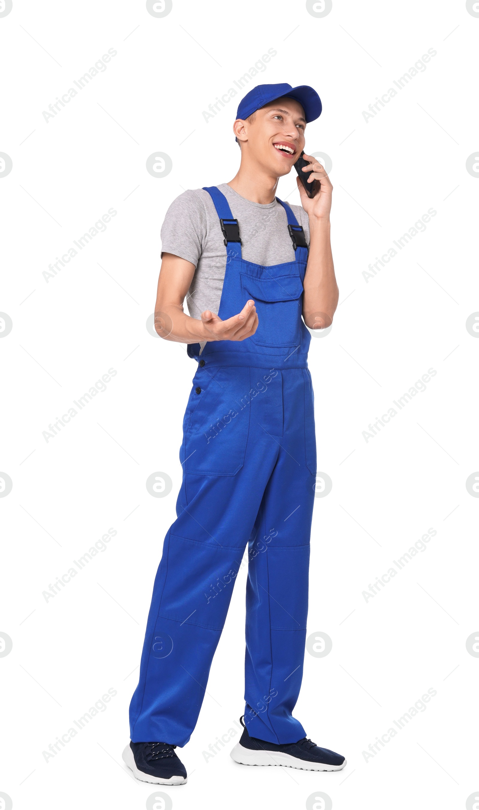 Photo of Smiling auto mechanic talking by smartphone on white background