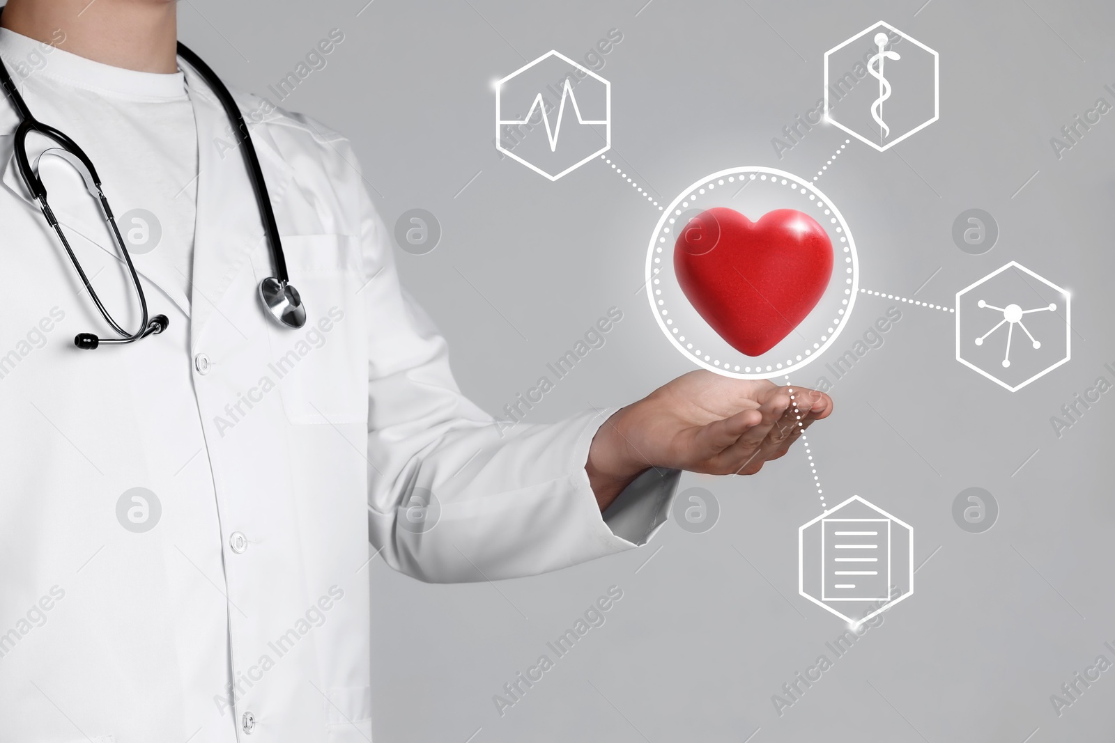 Image of Doctor holding red heart on grey background, closeup. Icons near hand