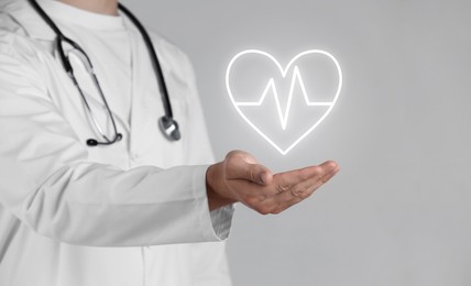 Image of Doctor holding digital heart on grey background, closeup