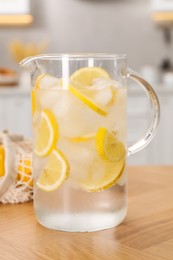 Photo of Freshly made lemonade in jug on wooden table indoors