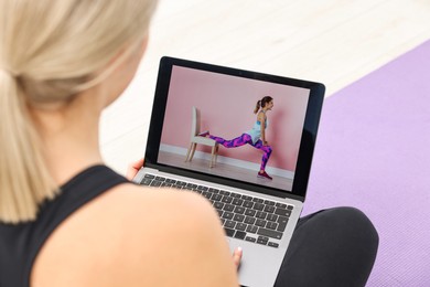 Photo of Online fitness trainer. Woman watching tutorial on laptop indoors, closeup