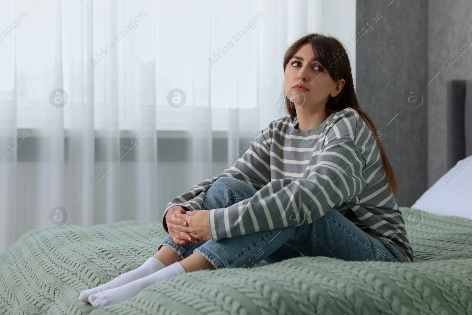 Photo of Loneliness concept. Sad woman sitting on bed at home