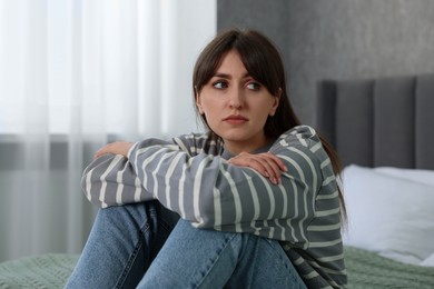 Photo of Loneliness concept. Sad woman sitting on bed at home