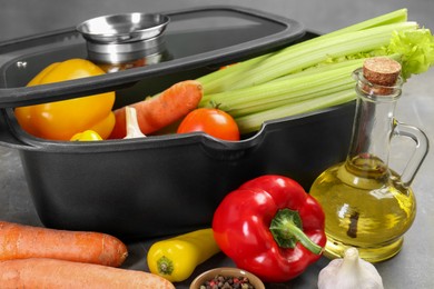 Photo of Black pot and fresh products on grey table