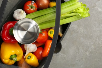 Photo of Black pot with fresh vegetables on grey table, top view. Space for text