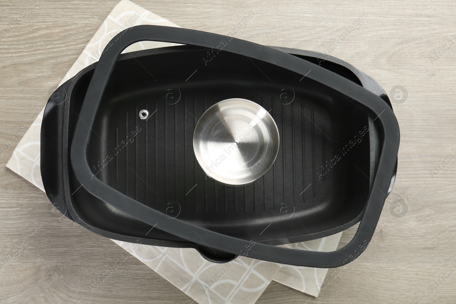 Photo of Black pot with glass lid on wooden table, top view