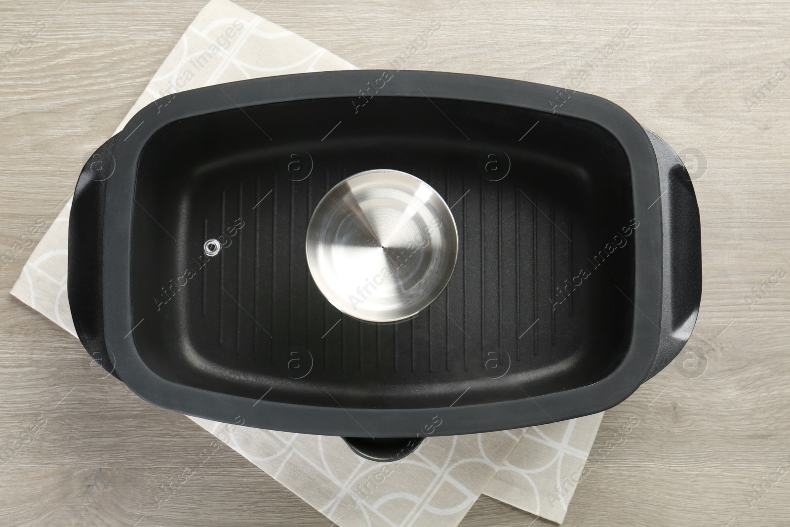 Photo of Black pot with glass lid on wooden table, top view