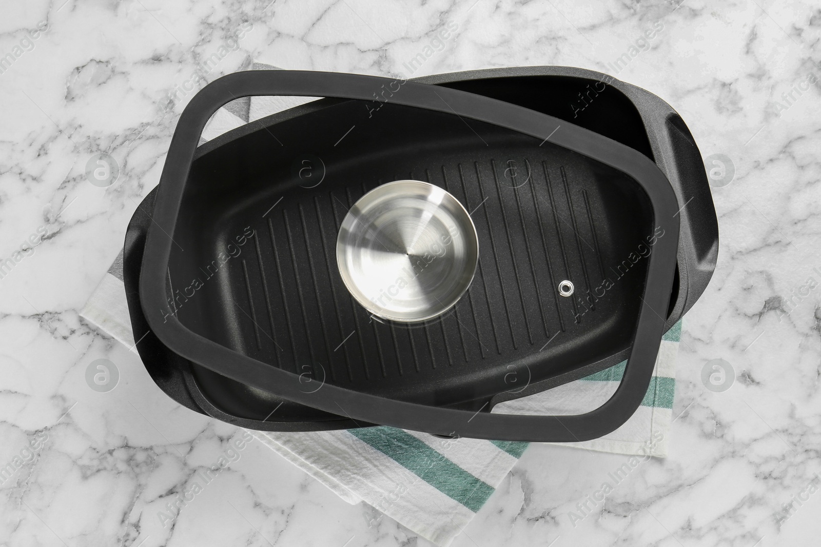 Photo of Black pot with glass lid on white marble table, top view