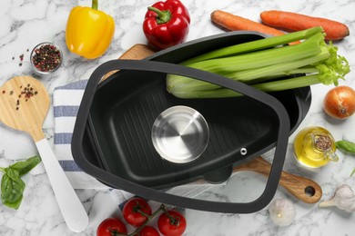 Photo of Black pot with glass lid, round spatula and different products on white marble table, flat lay