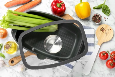 Photo of Black pot with glass lid, round spatula and different products on white marble table, flat lay