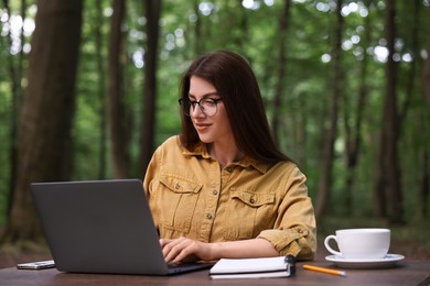 Freelancer working with laptop at table outdoors. Remote job