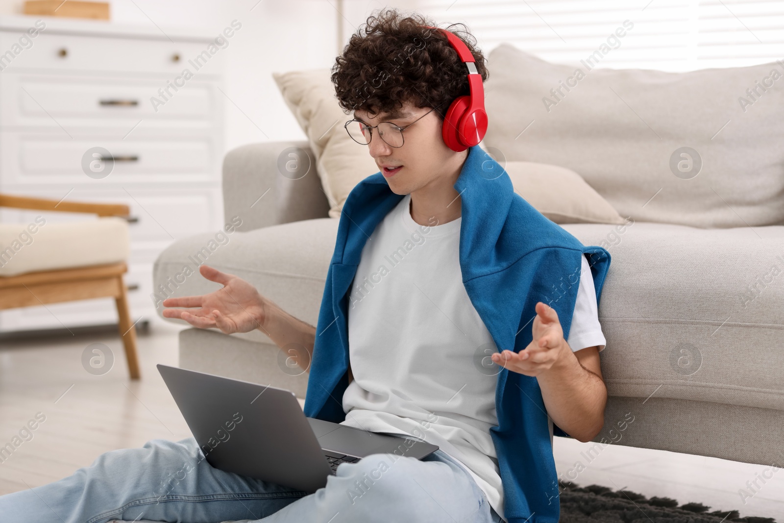 Photo of Teenager in headphones having video chat via laptop at home. Remote work